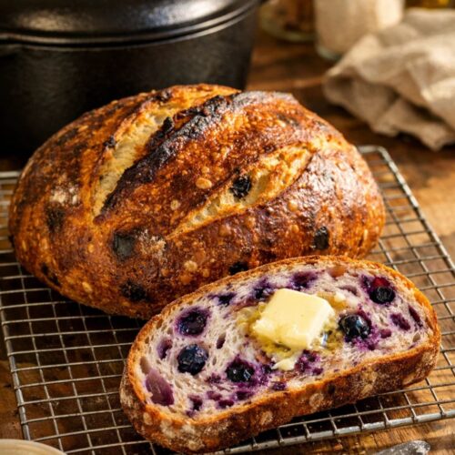Sliced sourdough blueberry bread with purple streaks.